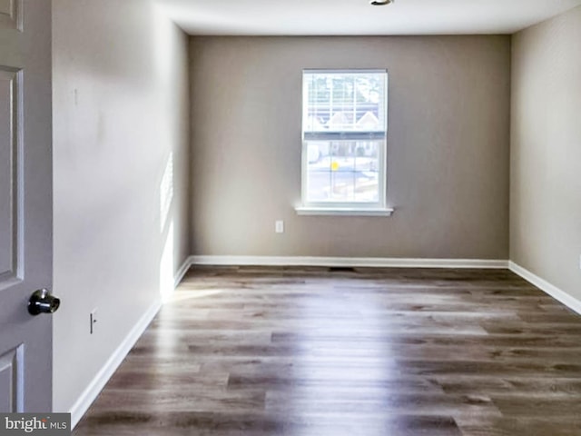 spare room with dark hardwood / wood-style flooring