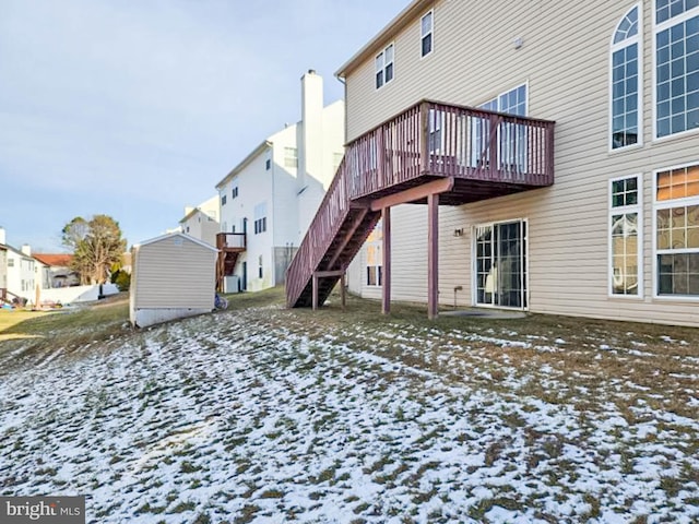 snow covered house featuring a wooden deck