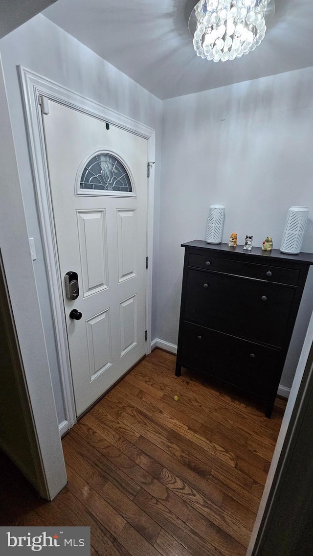 entryway with a notable chandelier and dark hardwood / wood-style flooring