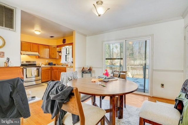 dining room with crown molding, sink, and light hardwood / wood-style floors