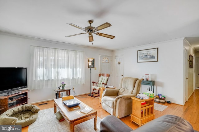 living room featuring ornamental molding, ceiling fan, and light wood-type flooring