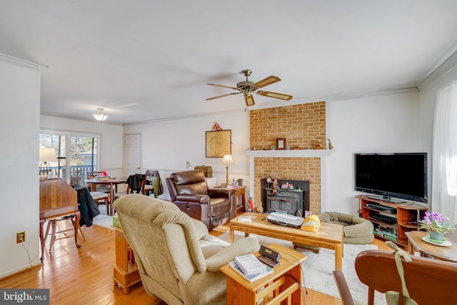 living room with crown molding, ceiling fan, and light hardwood / wood-style flooring