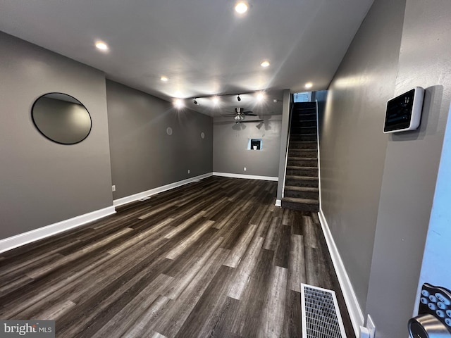 basement featuring ceiling fan and dark wood-type flooring