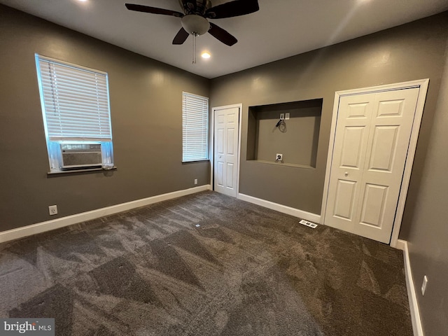 unfurnished bedroom with ceiling fan, dark carpet, and cooling unit