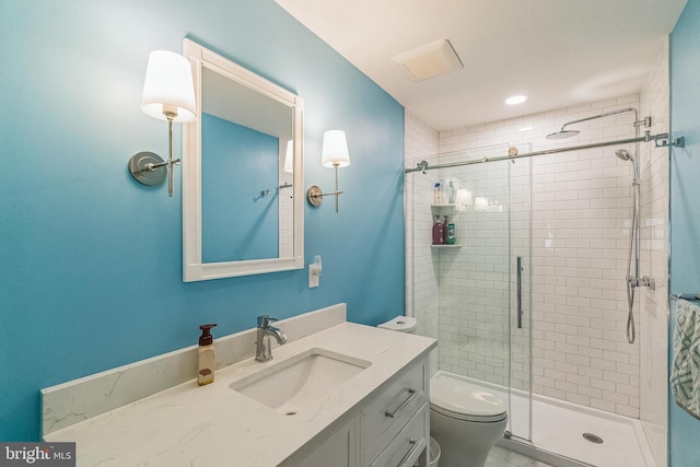 bathroom featuring toilet, vanity, and walk in shower