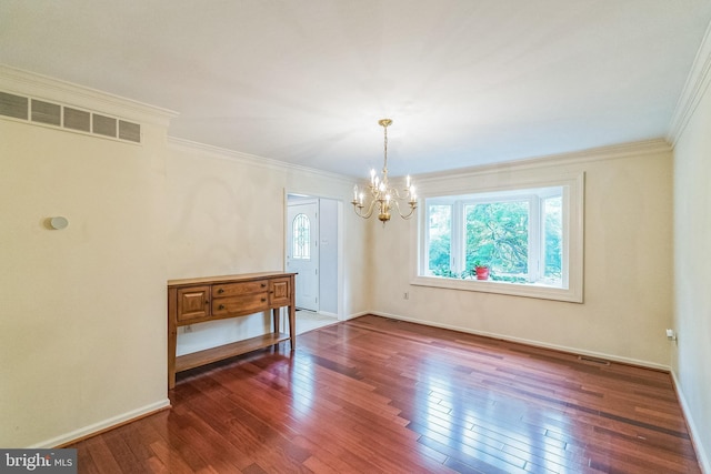 empty room with dark hardwood / wood-style flooring, an inviting chandelier, and ornamental molding