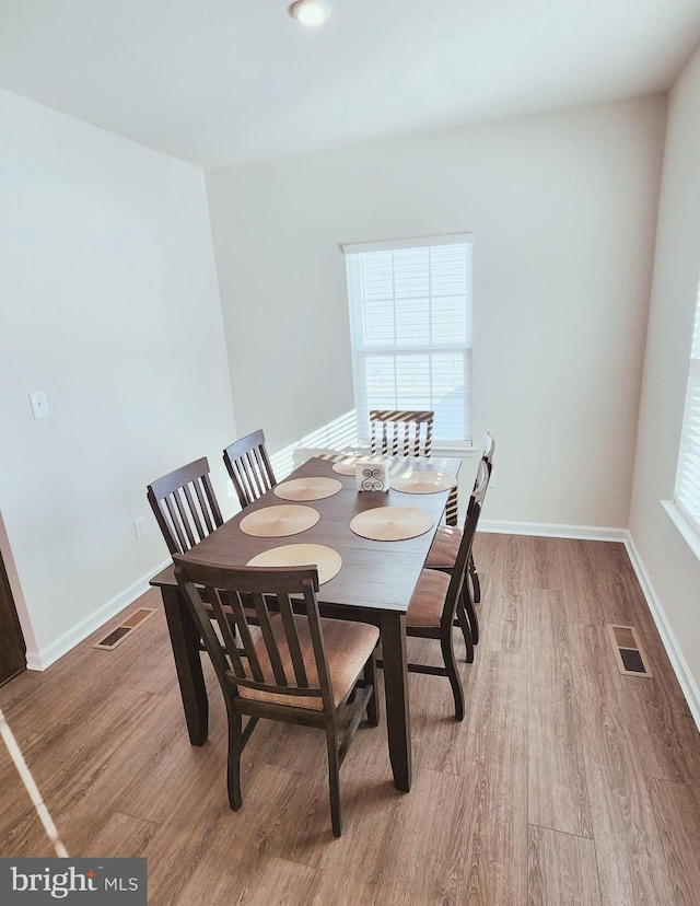 dining space with wood-type flooring