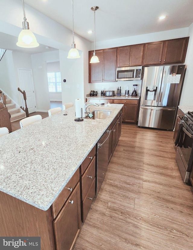 kitchen featuring a kitchen breakfast bar, sink, an island with sink, and stainless steel appliances