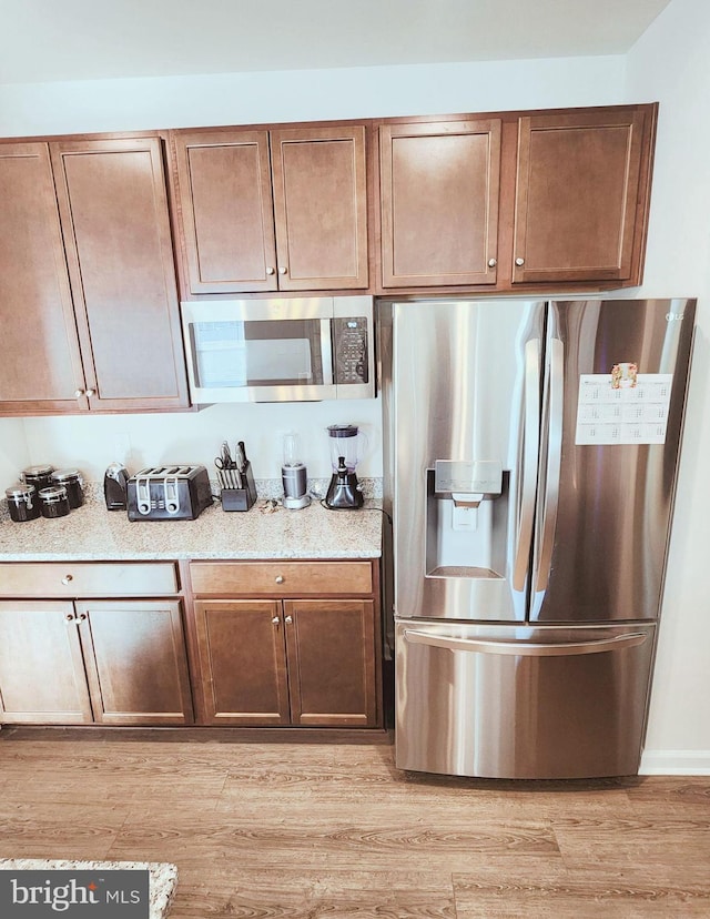 kitchen with stainless steel appliances and light hardwood / wood-style flooring