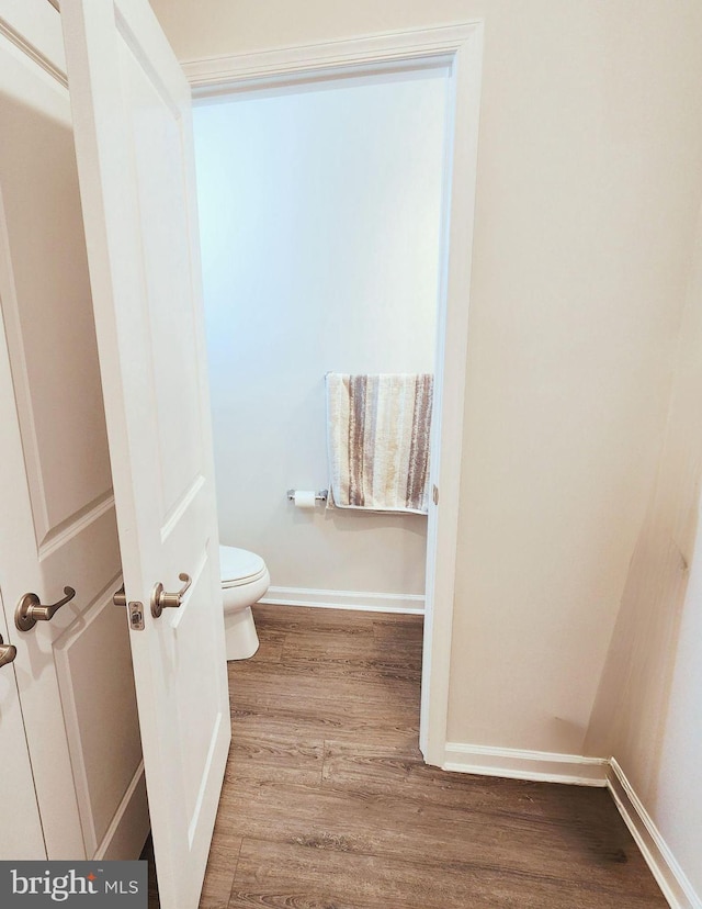 bathroom with hardwood / wood-style floors and toilet