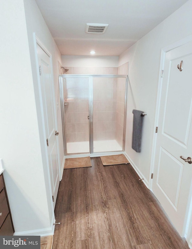 bathroom with vanity, an enclosed shower, and hardwood / wood-style flooring