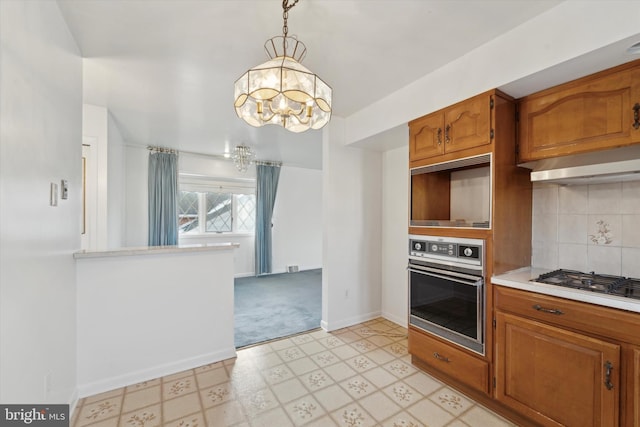 kitchen with stainless steel gas cooktop, light colored carpet, pendant lighting, black oven, and exhaust hood