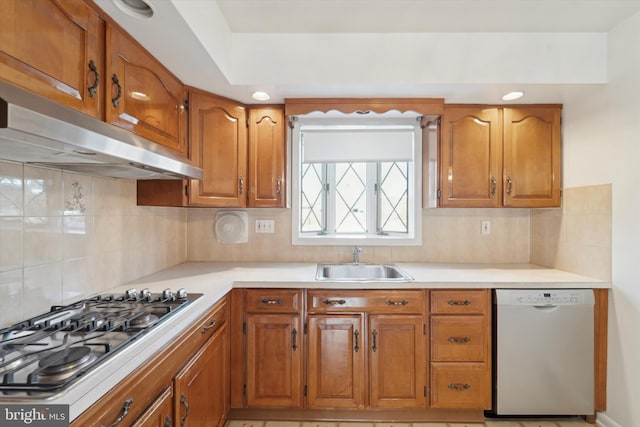 kitchen featuring backsplash, dishwashing machine, sink, and stainless steel gas stovetop