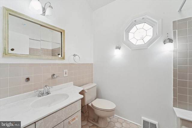 bathroom with tile patterned flooring, vanity, and toilet