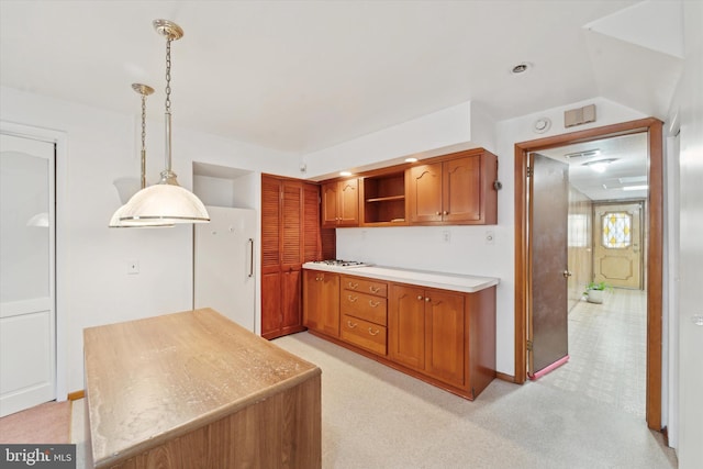 kitchen with decorative light fixtures, white fridge, and light colored carpet