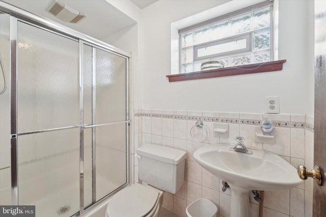 bathroom with toilet, tile walls, and walk in shower