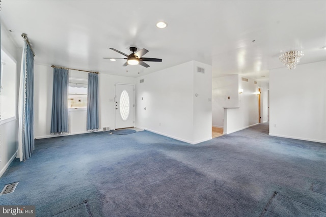 unfurnished living room featuring carpet floors and ceiling fan with notable chandelier