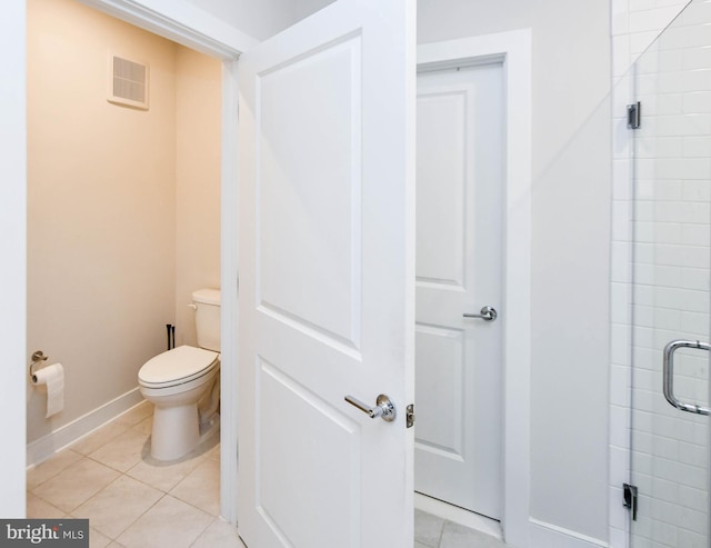 bathroom featuring tile patterned floors, a shower with door, and toilet