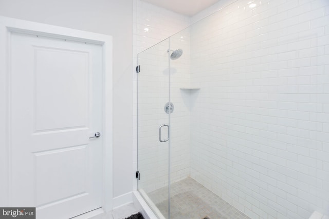 bathroom featuring a shower with shower door