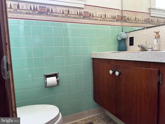 bathroom with vanity, tile walls, and toilet