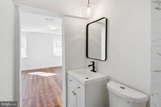 bathroom with vanity, wood-type flooring, and toilet