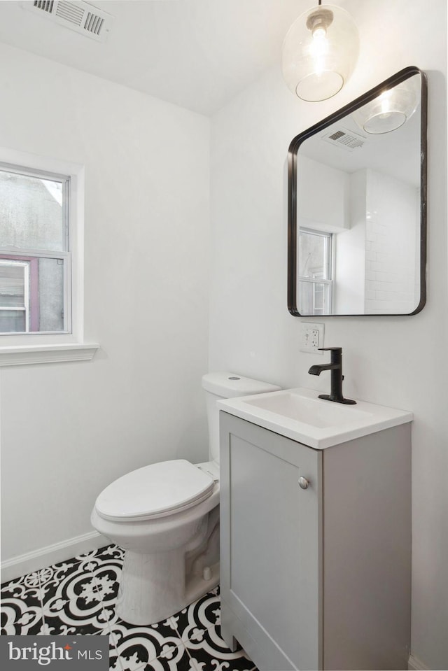 bathroom with tile patterned flooring, vanity, and toilet