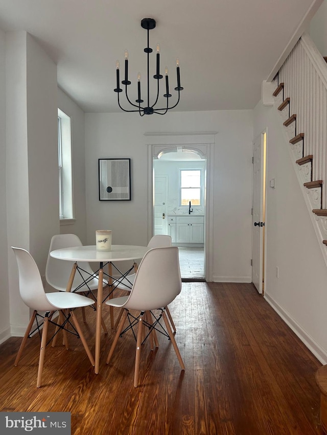 dining space featuring dark hardwood / wood-style floors and a notable chandelier