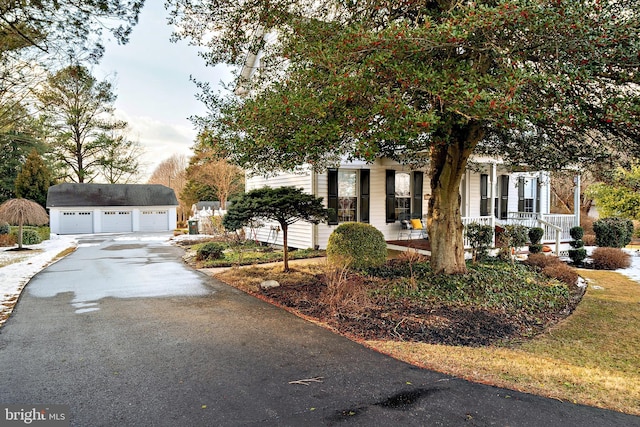 view of front of house featuring covered porch, an outdoor structure, and a garage