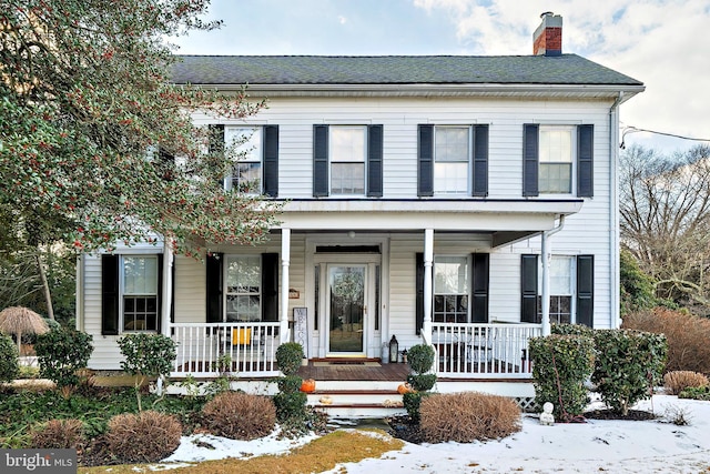 view of front of home with a porch and a chimney