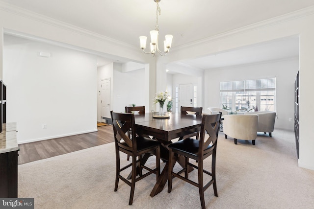 dining space with an inviting chandelier, carpet, and crown molding