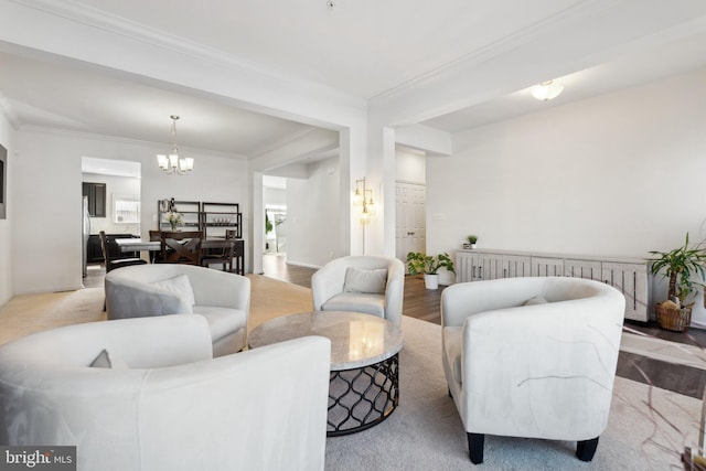 living room with an inviting chandelier, light hardwood / wood-style floors, and crown molding