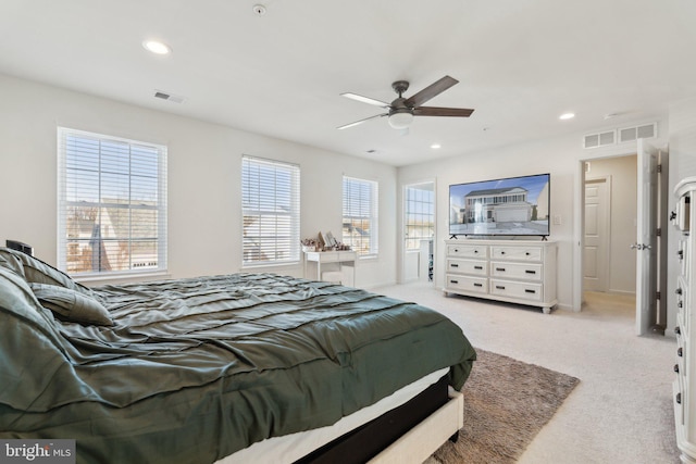 bedroom with multiple windows, light carpet, and ceiling fan