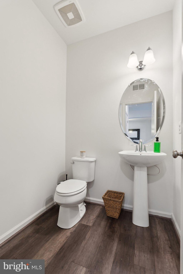 bathroom featuring toilet and wood-type flooring