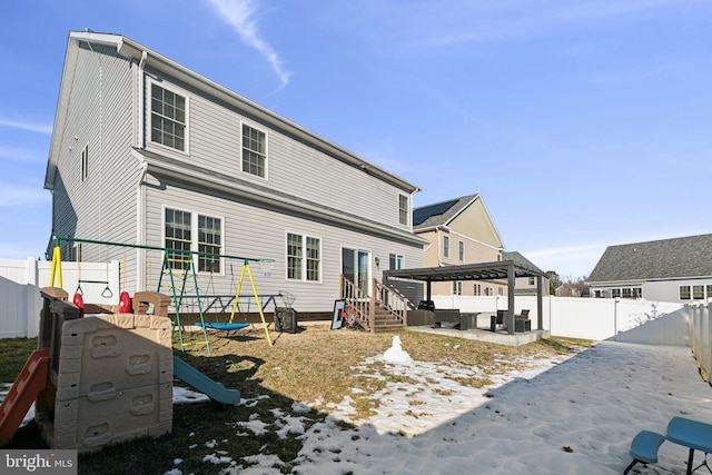 rear view of property featuring a gazebo and a playground