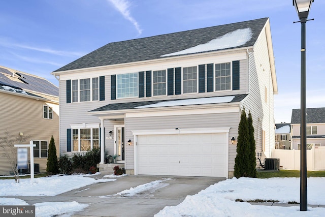 view of front of property featuring central air condition unit and a garage