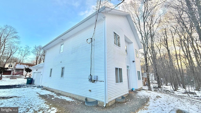 snow covered property with a garage