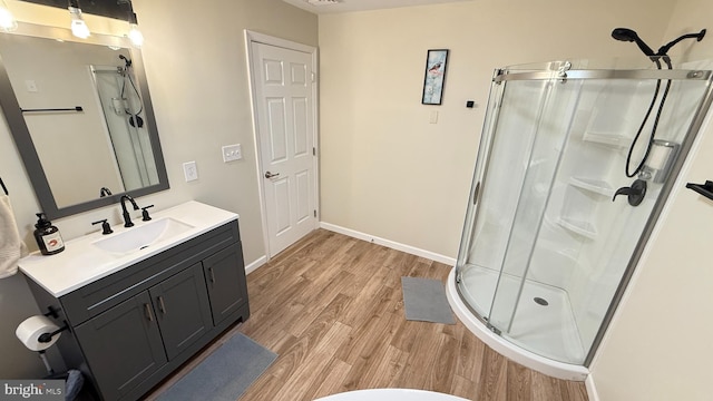 bathroom featuring wood-type flooring, vanity, and a shower with door