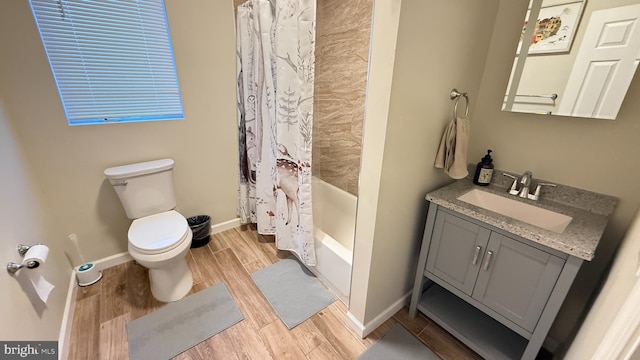 full bathroom with hardwood / wood-style floors, vanity, toilet, and shower / bath combo with shower curtain