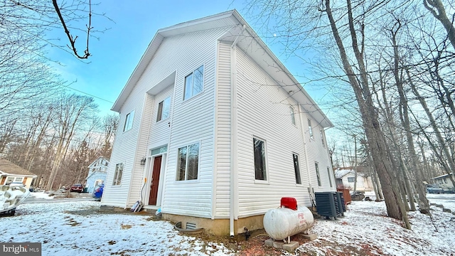 view of snowy exterior featuring cooling unit