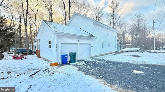 view of snowy exterior with a garage