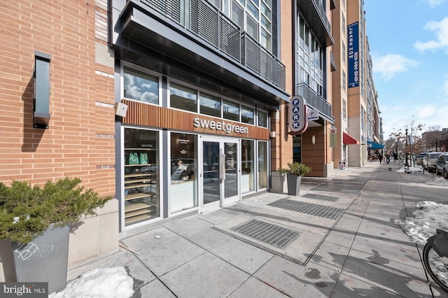 property entrance featuring french doors and brick siding