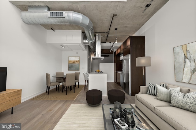 living room with visible vents, track lighting, baseboards, and wood finished floors