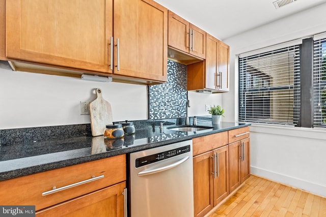 kitchen with dishwasher, light wood-type flooring, sink, and dark stone countertops