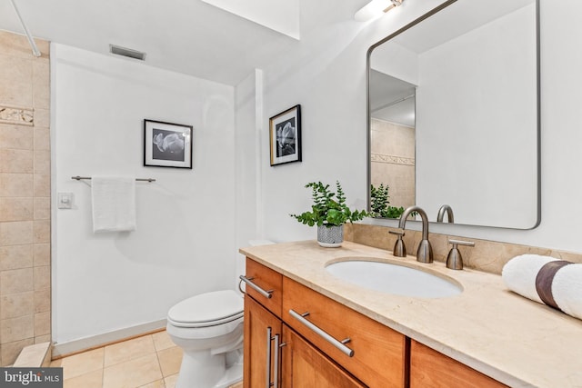 bathroom with tile patterned flooring, vanity, and toilet