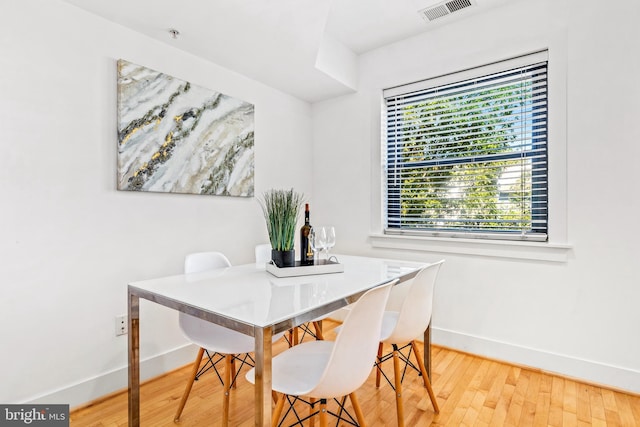 dining space with wood-type flooring