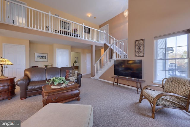 carpeted living room with a towering ceiling