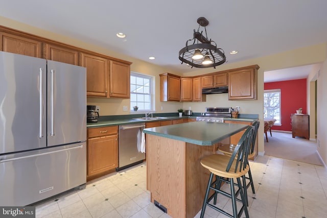 kitchen with sink, decorative light fixtures, a center island, a breakfast bar area, and appliances with stainless steel finishes