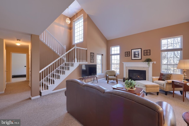 carpeted living room with high vaulted ceiling and a wealth of natural light