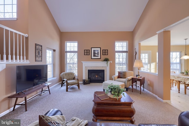 living room with high vaulted ceiling, plenty of natural light, and carpet