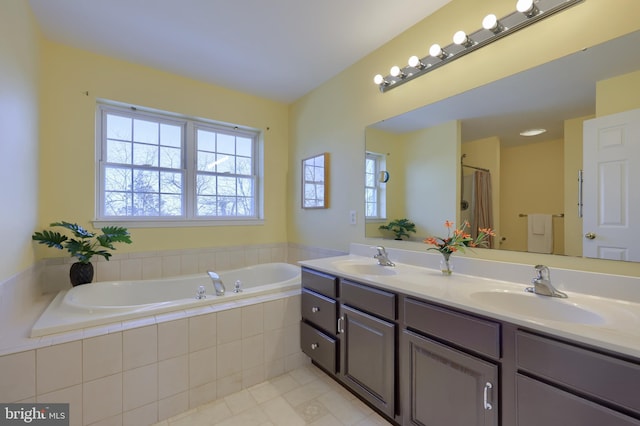 bathroom featuring tile patterned flooring, tiled tub, and vanity